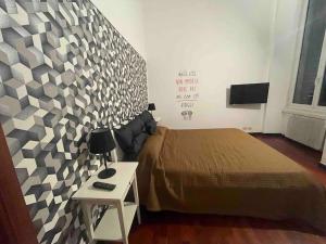 - une chambre avec un lit et un mur avec une table dans l'établissement Appartamento “Il Grifone”, à Gênes