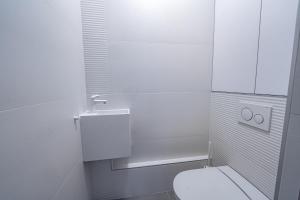 a white bathroom with a toilet and a sink at Superbe 2 pièces 52 m2 refait à neuf Boulogne Nord - Superb brand new 1 bedroom appartement North of Boulogne in Boulogne-Billancourt