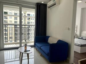 sala de estar con sofá azul y ventana en Ho Chi Minh 2 Beds 2 Baths APT, en Ho Chi Minh