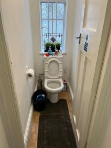 ein kleines Bad mit einem WC und einem Fenster in der Unterkunft The Rumah at Hyde Park in London