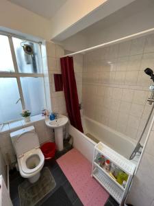 ein Badezimmer mit einem WC, einer Badewanne und einem Waschbecken in der Unterkunft The Rumah at Hyde Park in London