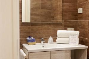 bagno con lavandino bianco e piastrelle marroni di U259 B&b a Napoli