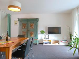 une salle à manger avec une table et une télévision dans l'établissement Alpenrose, à Obermaiselstein