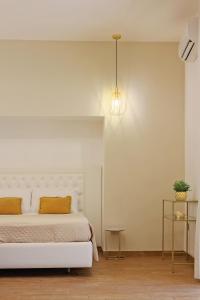 una camera da letto con un letto bianco con cuscini gialli di U259 B&b a Napoli