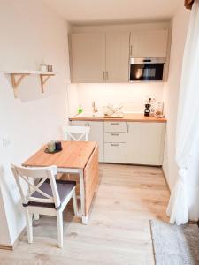 eine kleine Küche mit einem Holztisch und einem Stuhl in der Unterkunft LOBE Apartment in Bad Mitterndorf