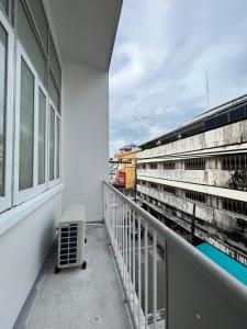 a balcony with a train passing by a building at Muangchan Hotel in Chanthaburi