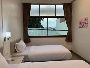 Postel nebo postele na pokoji v ubytování Muangchan Hotel