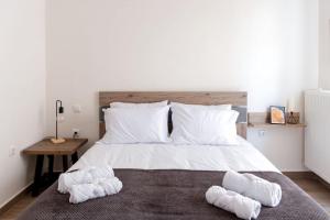 1 dormitorio con 1 cama blanca grande y toallas. en Lake View Terrace Apartment, en Kastoria