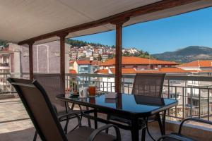 una mesa y sillas en un balcón con vistas en Lake View Terrace Apartment, en Kastoria