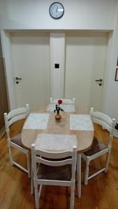stół jadalny z krzesłami i zegarem na ścianie w obiekcie Apartman Katarina w mieście Čakovec