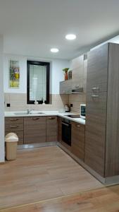 a large kitchen with wooden cabinets and a sink at Apartman Katarina in Čakovec