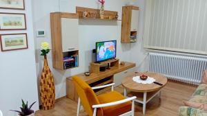 sala de estar con mesa pequeña y TV en Apartman Katarina, en Čakovec