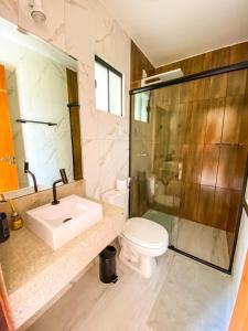 uma casa de banho com um lavatório, um WC e um chuveiro em Entre Serras Gastropub e Chalés em Monte das Gameleiras