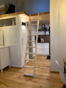 een houten trap in een kamer met een keuken bij Zentrale 1-Zimmer-Wohnung in der Altstadt in Landsberg am Lech