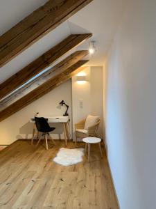 Cette chambre mansardée comprend un bureau et des chaises. dans l'établissement Zentrale 1-Zimmer-Wohnung in der Altstadt, à Landsberg am Lech