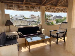 a living room with a couch and chairs and a table at Ttunu House in Lamu