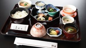 福山市にある福山ニューキャッスルホテルのテーブルの上に様々な種類の食料を詰めたトレイ