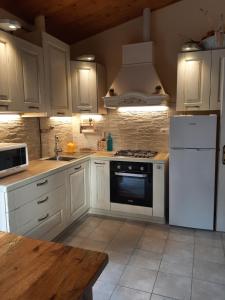 a kitchen with white cabinets and a stove and refrigerator at Villa Finetti in Gubbio