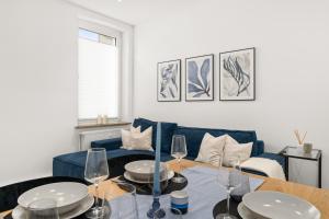 a living room with a blue couch and a table at SHINY HOMES - Kitchen - Free Parking - Netflix in Bielefeld