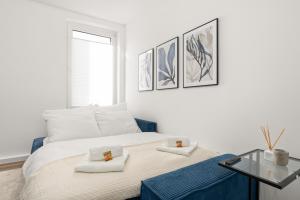 a white bedroom with a bed and a glass table at SHINY HOMES - Kitchen - Free Parking - Netflix in Bielefeld