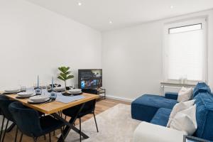 a living room with a table and a blue couch at SHINY HOMES - Kitchen - Free Parking - Netflix in Bielefeld