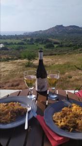 Molivos Castleview Luxury Villa في ميثيمنا: طاولة مع طبقين من الطعام وزجاجة من النبيذ