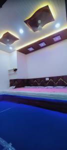 a bed in a room with a blue light at Hotel PRABHU PALACE in Ujjain