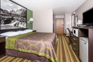 a hotel room with a bed and a flat screen tv at Super 8 by Wyndham Rock Springs in Rock Springs