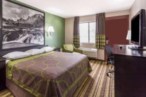 pokój hotelowy z łóżkiem i telewizorem z płaskim ekranem w obiekcie Super 8 by Wyndham Rock Springs w mieście Rock Springs