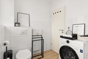 eine weiße Waschküche mit Waschmaschine und Trockner in der Unterkunft SHINY HOMES - Elegant City Apartments in Bielefeld + 65 Fotos