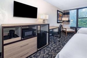 a hotel room with a bed a desk and a tv at Ramada by Wyndham West Atlantic City in West Atlantic City