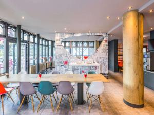 パリにあるイビス パリ ガレ ドゥ リヨン レデュー ローランの窓付きの客室で、大きなテーブルと椅子が備わります。