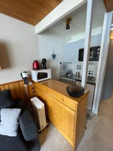 eine Küche mit einer Theke mit einer Spüle und einer Mikrowelle in der Unterkunft Chaleureux studio à 150m du Point Show in Vars