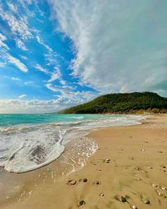 a beach with footprints in the sand and the ocean at karaöz lighthouse bungalow in Kumluca