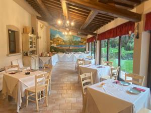 ein Restaurant mit Tischen und Stühlen mit weißem Tischtuch in der Unterkunft La Locanda dei Golosi in Bosco