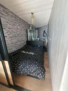 um quarto com uma cama preta e uma parede de tijolos em Vue mer exceptionnelle em La Grande-Motte