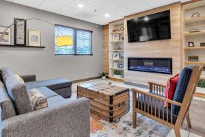 a living room with a couch and a tv at Country Inn & Suites by Radisson Rehoboth Beach - Dewey in Rehoboth Beach