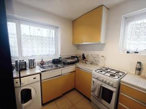 cocina con fregadero y fogones horno superior en City Airport Apartment en Londres