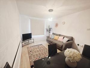 a living room with a couch and a table at City Airport Apartment in London