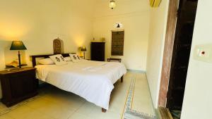 a bedroom with a large white bed in a room at Mosaics Guest House in Jaipur