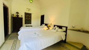 - deux lits assis l'un à côté de l'autre dans une pièce dans l'établissement Mosaics Guest House, à Jaipur