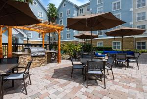 a patio with tables and chairs and an outdoor grill at Homewood Suites by Hilton Lake Mary in Lake Mary