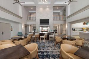 un restaurante con mesas, sillas y TV en Homewood Suites by Hilton Lake Mary, en Lake Mary