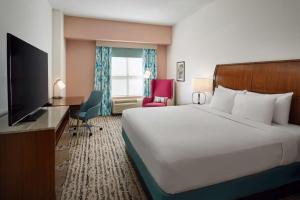 a hotel room with a bed and a flat screen tv at Hilton Garden Inn Atlanta Midtown in Atlanta