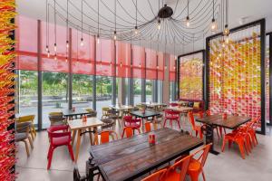 - un restaurant avec des tables, des chaises et de grandes fenêtres dans l'établissement Hampton by Hilton Dubai Al Seef, à Dubaï