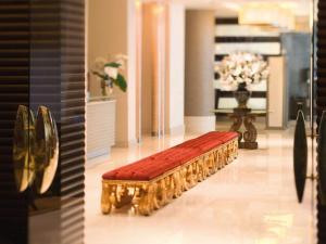 a bench with a red cushion in a room at Mövenpick Hotel Izmir in İzmir