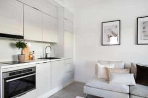a kitchen with white cabinets and a couch at Top Floor Tarutie in Kirkkonummi