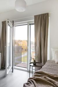 a bedroom with a bed and a view of a balcony at Top Floor Tarutie in Kirkkonummi