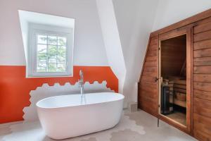 a bathroom with a white tub and a wooden cabinet at Appartement de 100m2 dans un parc à 20 mn du centre de Paris in Garches +33 photos