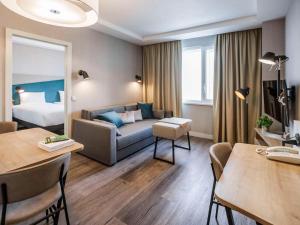 a hotel room with a couch and a bed at Adagio Kyiv Beresteiska in Kyiv